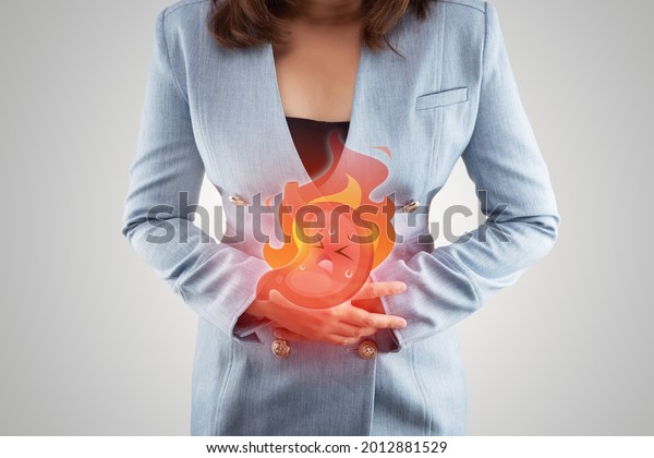 Acid reflux disease symptoms or heartburn,\
illustration stomach burn on woman\'s body against gray backgroundd,\
Concept with healthcare and\
medicine