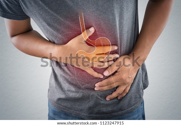 Acid reflux or Heartburn, The photo\
of stomach and internal organs is on the men\'s body against gray\
background, Stomach ache, Bad health, Male anatomy\
concept.