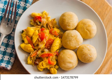 Ackee and Salt fish served with fried dumplings and served on a white plate