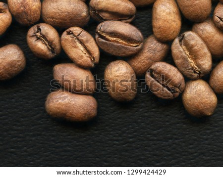 ackground of freshly dark roasted coffee beans on black