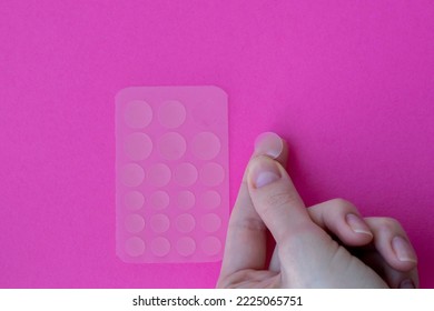 Acne Patches On A Pink Background. One Patch On A Woman's Hand, Ready To Stick To Problem Skin