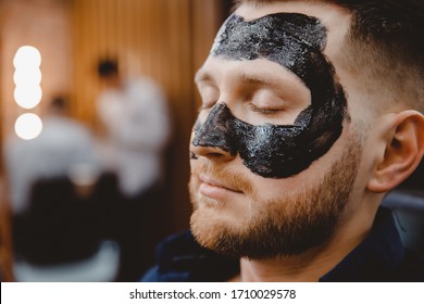 Acne Removal With Cosmetic Product, Cleaning Pores Of Men Skin, Barber Applying Black Charcoal Mask To Client Man In Spa Salon.