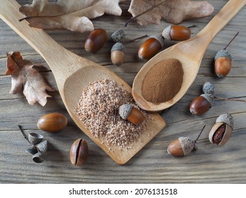 Acorn flour, ground powder in wooden spoons, oak fruits, acorns and leaves on a wooden table, top view, flat layout. Natural gluten-free cereals and decaffeinated coffee for use in dietary nutrition