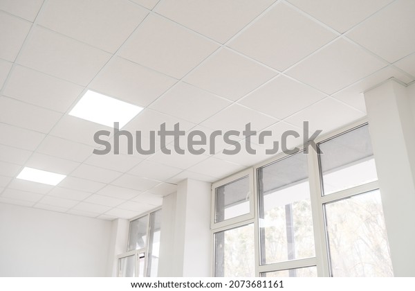 Acoustic ceiling with lighting and light channel\
window, Acoustic ceiling board texture Sound-proof material, Sound\
absorber, industry construction concept background black and white\
tone