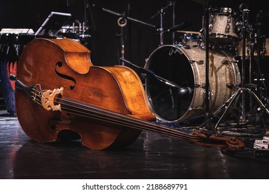 Acoustic double bass on stage with drums on background during a jazz concert