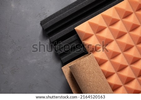 Acoustic foam and cork board at concrete wall background texture. Sound isolation material for record studio or house renovation