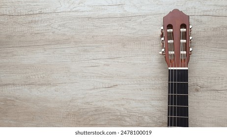 Acoustic guitar close up isolated on wooden floor with copy space. Part of a wooden acoustic guitar on the right side of the frame with blank space for text on the left. Horizontal banner for musical. - Powered by Shutterstock