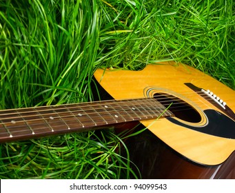 Acoustic guitar in green grass