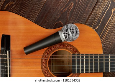 Acoustic guitar with microphone. Grey microphone on classical guitar. Traditional musical instrument.
