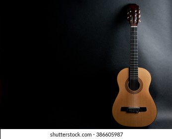 Acoustic guitar on a black background (with copy space)