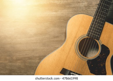 Acoustic Guitar On Vintage Wooden Background With Sunlight Effect Filter. 