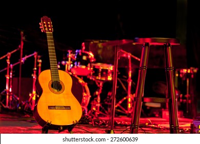 Acoustic Guitar Over Blurry Music Stage Background