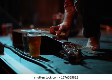 Acoustic Guitar And A Pint Of Beer Rest On Stage At A Small Gig Venue