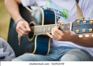 Acoustic Guitarist. Young Man Playing Blue Acoustic Guitar. Summer Outside.