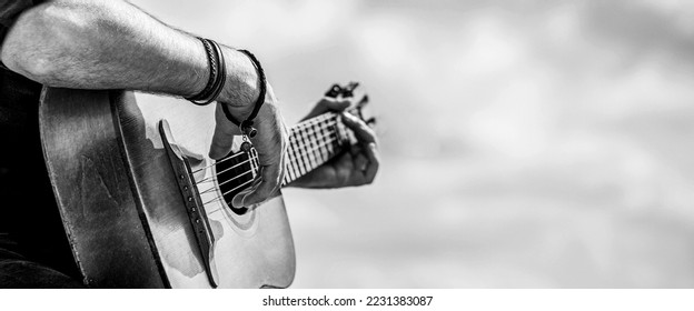 Acoustic guitars playing. Music concept. Black and white. Male musician playing guitar, music instrument. Man's hands playing acoustic guitar, close up. - Powered by Shutterstock