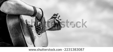 Acoustic guitars playing. Music concept. Black and white. Male musician playing guitar, music instrument. Man's hands playing acoustic guitar, close up.