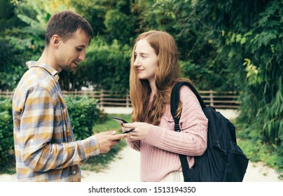 Acquaintance Of A Guy And A Girl Outside In A Park. Exchange Phone Numbers. Flirty Lifestyle.