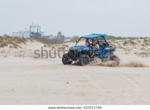 Acre, Israel - April 15, 2015 : Young man drives\
extreme on his off-road vehicle along the Mediterranean sea coast\
near Acre, Israel