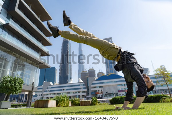 Acrobat keep
balance one the hands with blurred Dubai cityscape. Concept of
modern, business and unlimited possibility
