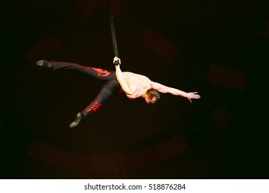 Acrobat performs a difficult trick in the circus.
