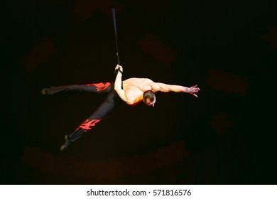 Acrobat performs a difficult trick in the circus.