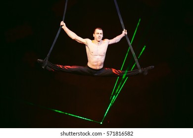 Acrobat performs a difficult trick in the circus.