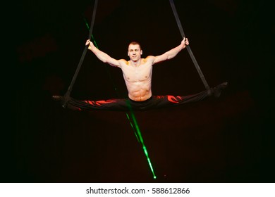 Acrobat performs a difficult trick in the circus.