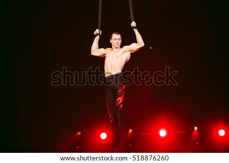 Acrobat performs a difficult trick in the circus.