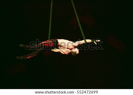 Acrobat performs a difficult trick in the circus.