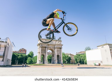 Acrobatic biker jumping with his bicycle on the streets - Bmx bicycle rider tricking outdoors - Powered by Shutterstock