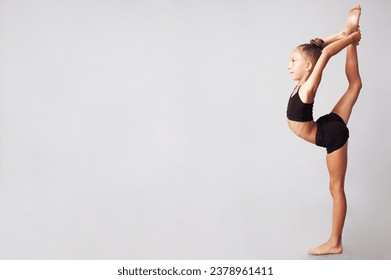 Acrobatic choreography concept. Full length profile portrait of smiling young little gymnast showing her skills isolated on gray background. Copy-space. Studio shot - Powered by Shutterstock