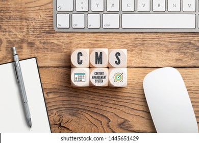 Acronym CMS On Cubes In Front Of A Computer Keyboard