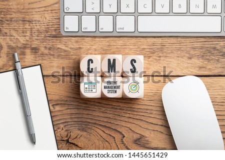 acronym CMS on cubes in front of a computer keyboard