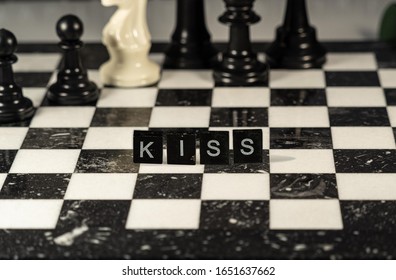 the acronym kiss for keep it simple stupid concept represented by wooden letter tiles