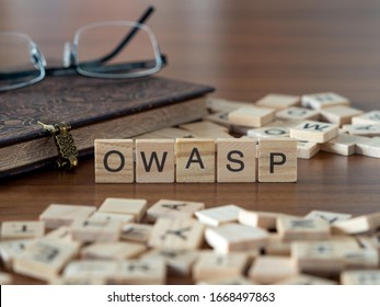 The Acronym Owasp For Open Web Application Security Project Concept Represented By Wooden Letter Tiles On A Wooden Table With Glasses And A Book