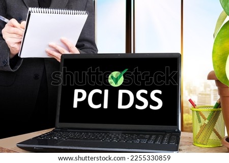 the acronym PCI DSS  on computer screen. businessman holding a notebook