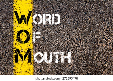 Acronym WOM as Word Of Mouth. Yellow paint line on the road against asphalt background. Conceptual image