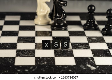 The acronym XSS for Cross-Site Scripting attack an OWASP top 10 threat represented by black and white letter tiles on a marble chessboard with chess pieces