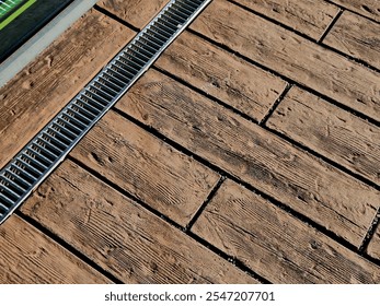 across the path there is a channel with a metal grid for drainage interlocking paving. the water is drained from the surface into the gutter and further into the rain sewer - Powered by Shutterstock