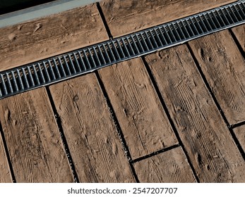 across the path there is a channel with a metal grid for drainage interlocking paving. the water is drained from the surface into the gutter and further into the rain sewer - Powered by Shutterstock