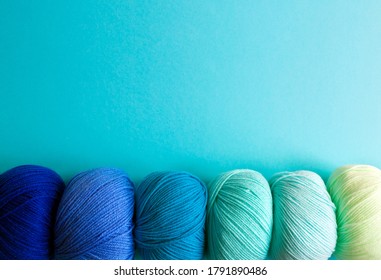 Acrylic balls of yarn on a blue background. Nuance color combination. The skeins are located horizontally at the bottom.