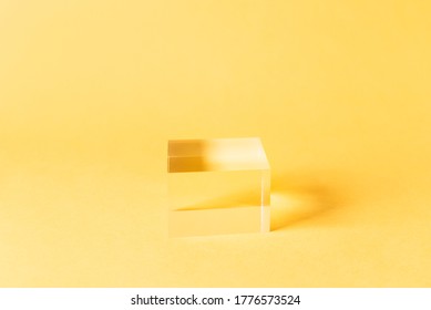 Acrylic Solid Display Block for Shop Windows on bright yellow background, empty podium for product presentation, geometric stand for cosmetics - Powered by Shutterstock - Get 15% off with code: PIKWIZARD15