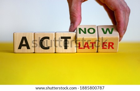 Act now, not later symbol. Male hand turns wooden cubes and changes words 'act later' to 'act now'. Business and act now or later concept. Beautiful yellow table, white background, copy space.