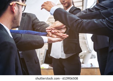 Action of business people joining hands showing teamwork, collaboration and unity. - Shutterstock ID 613906508