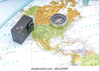Action camera and compass with map background. Travelling concept