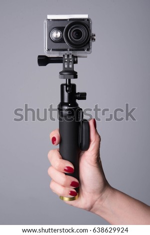 Action camera with monopod in a hand