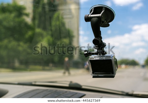 Action\
camera with suction cap on car windshield window, filming the\
driving experience in urban traffic\
environment