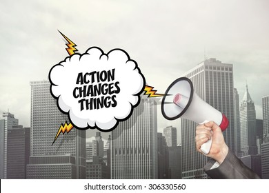Action changes things text on speech bubble and businessman hand holding megaphone on cityscape background