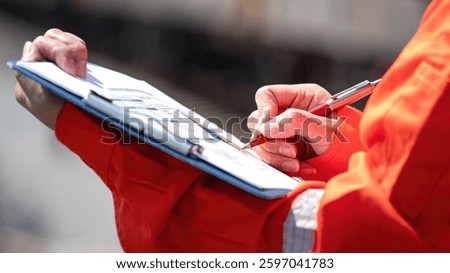 Action of an engineer is checking on the chemical hazard material form with background of crude oil or chemical transportation via train or railroad. Industrial safety working concept, close-up.