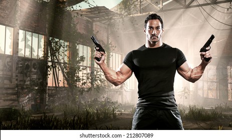 Action Hero Muscled Man Holding Two Guns. Standing In Abandoned Building. Wearing Black T-shirt And Pants.